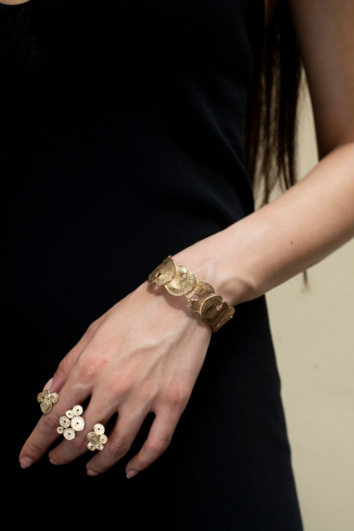 bracciale rigido in bronzo dorato realizzato a mano che imita le forme botaniche delle foglie di fior di loto indossato (per meglio omprendere l'ingombro sul polso)