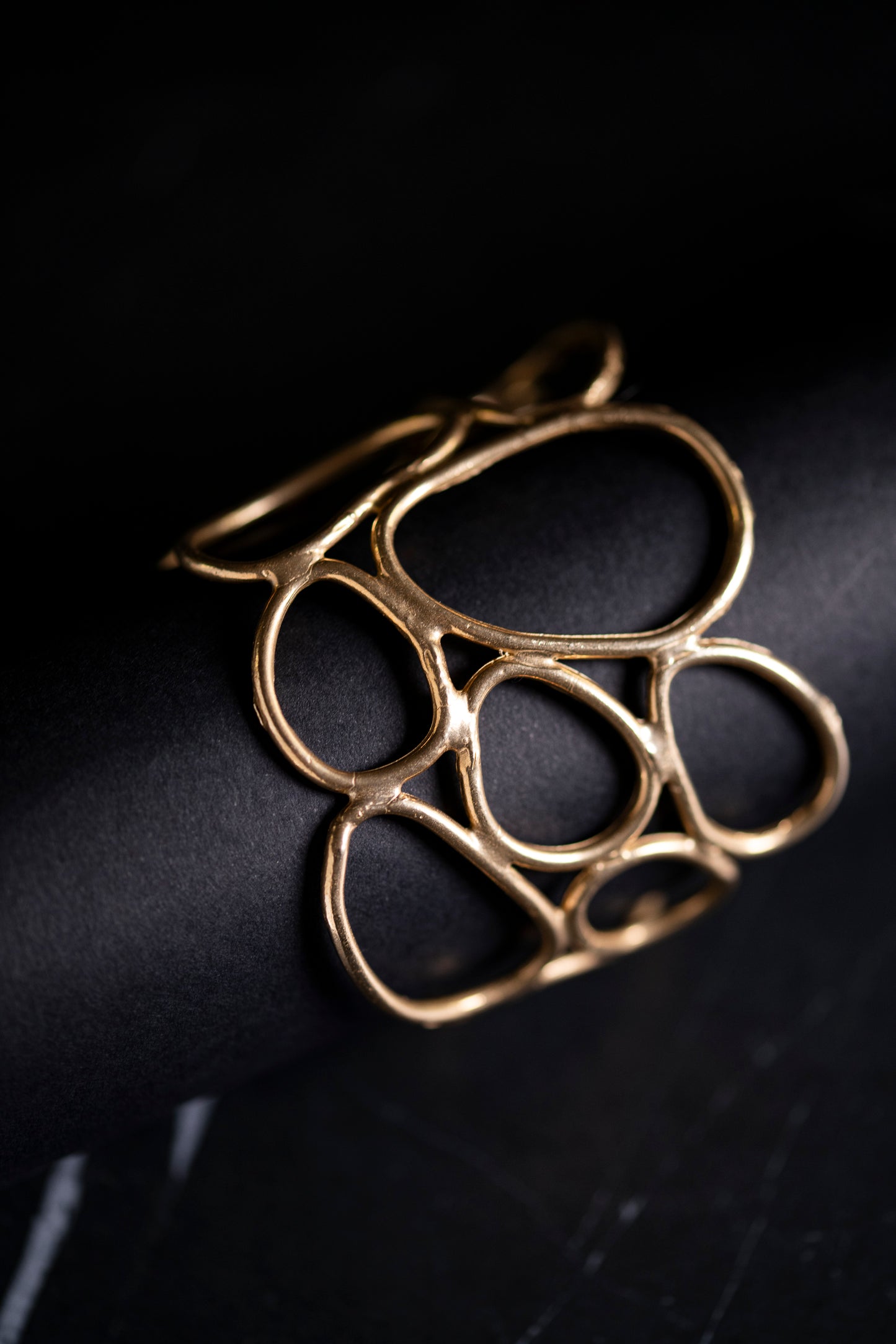 bracciale rigido in bronzo realizzato a partire da anelli irregolari di materiale