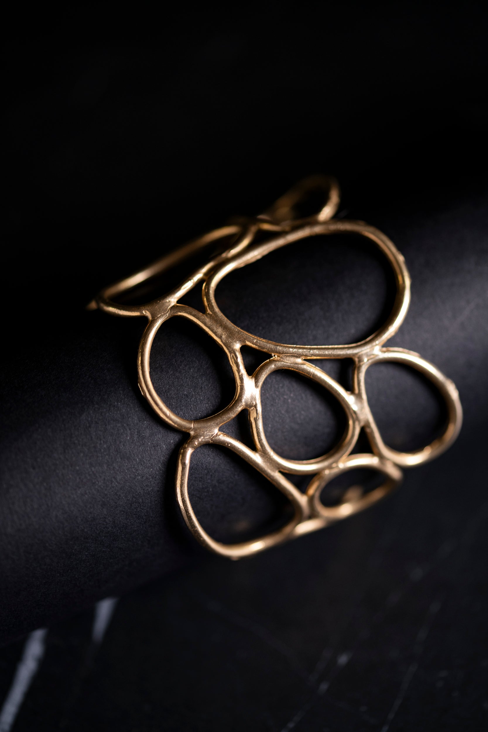 bracciale rigido in bronzo realizzato a partire da anelli irregolari di materiale
